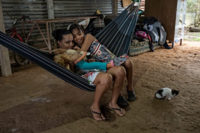 Susana abraza a su mamá, Deisy, y a su muñeca favorita, mientras descansan en una hamaca en el patio de su casa. Foto: Víctor Galeano