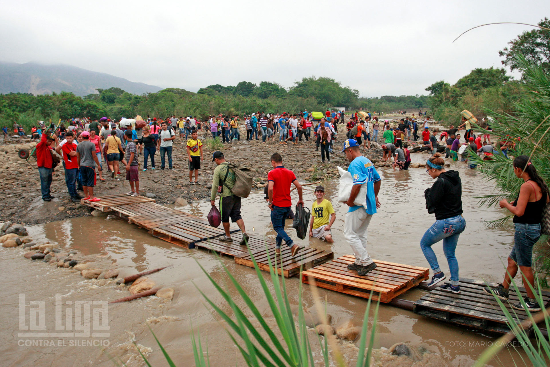 Venezolanos cruzan de Colombia a Venezuela después de comprar productos de primera necesidad. Atraviesan puentes artesanales construidos sobre el río Táchira en el corregimiento de La Parada, que une a Cúcuta con San Antonio del Táchira. | Crédito: Mario Caicedo.
