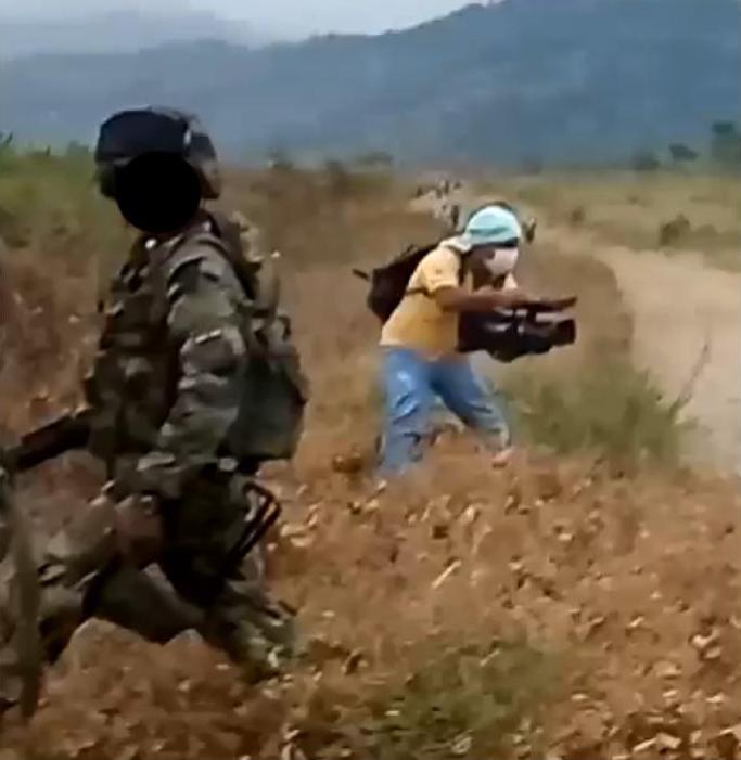 Abelardo Liz se ve con una camiseta amarilla filmando a lo largo de un camino de tierra donde estalló el tiroteo.