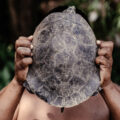 Un habitante del resguardo Curare Los Ingleses sostiene una tortuga charapa en el Bajo Río Caquetá.